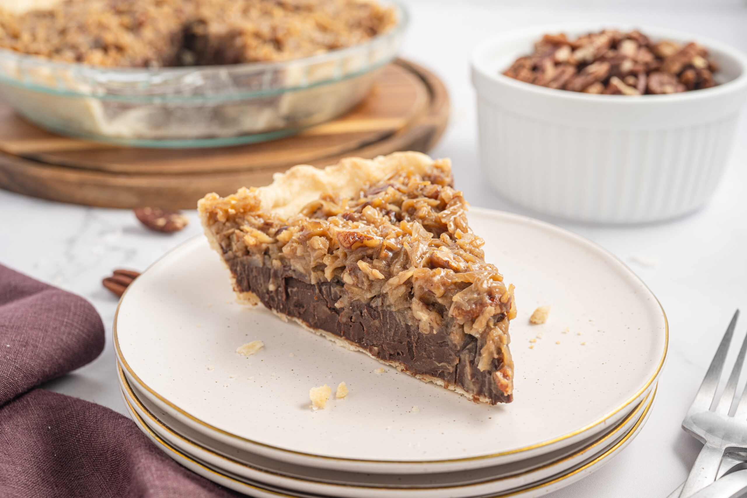 Slice of German Chocolate Pie on a stack of plates.