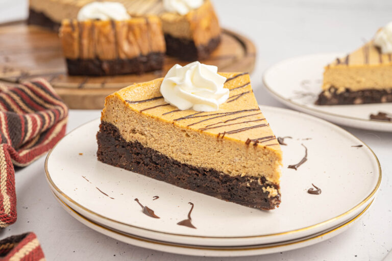 A slice of Brownie Bottom Pumpkin Cheesecake on a small plate.