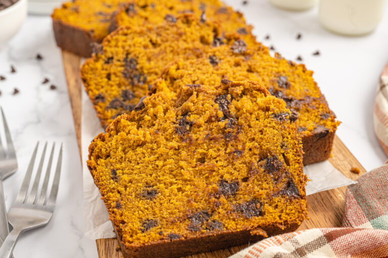 Chocolate Chip Pumpkin Loaf, sliced on a cutting board lined with parchment paper.