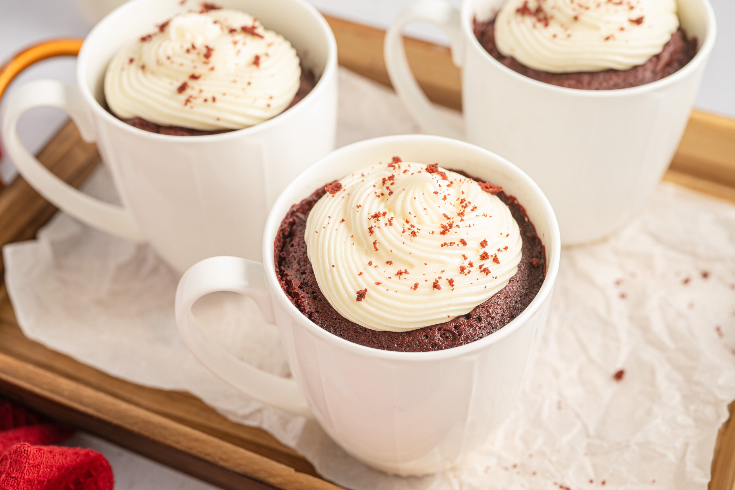 Red Velvet Mug Cake served on a tray lined with parchment paper.