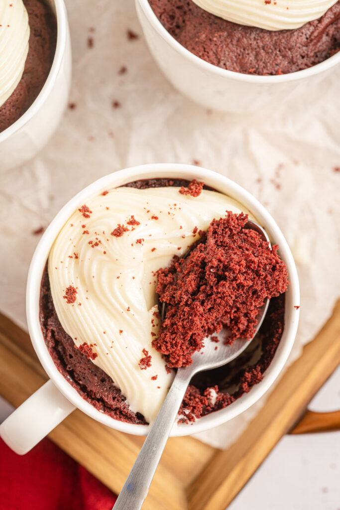 Red Velvet Mug Cake with a spoonful resting on top of the mug.