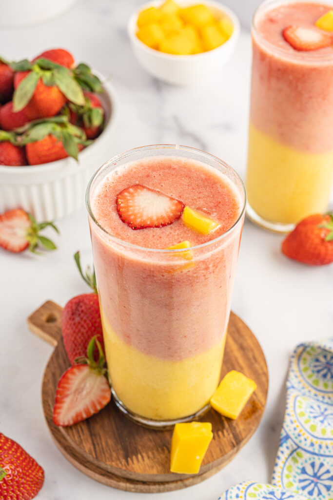 Strawberry Mango Smoothie served on wooden coasters on a table.