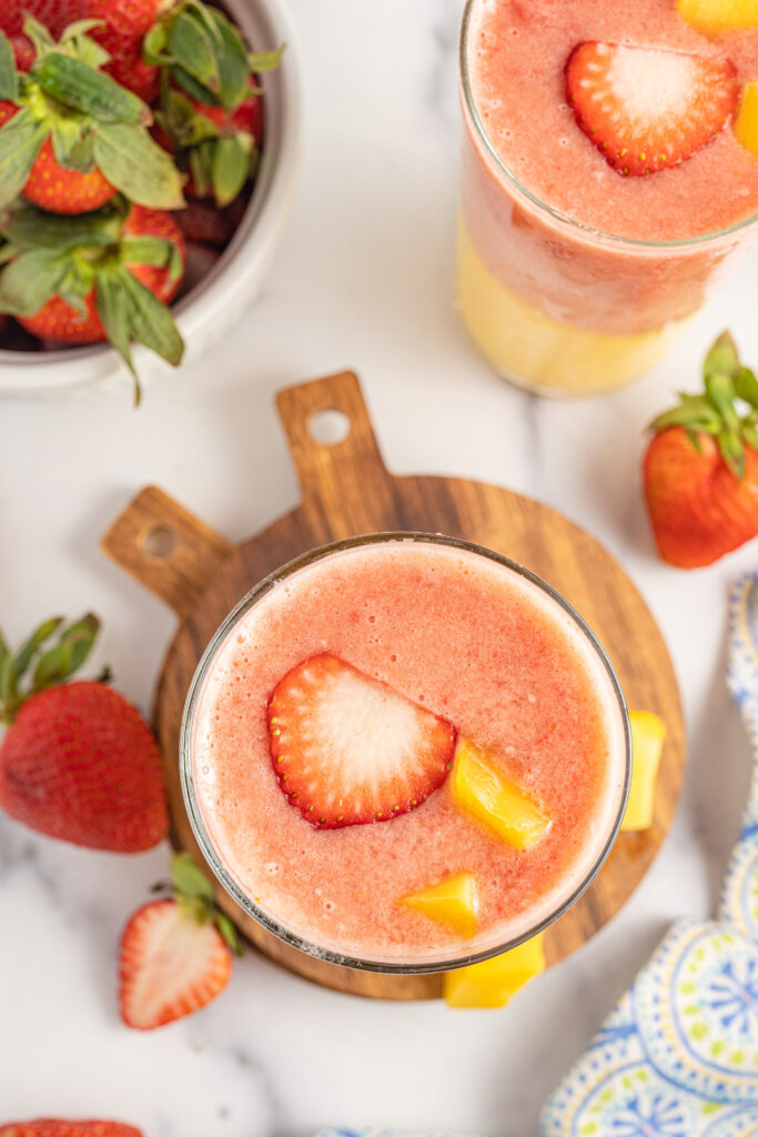 Strawberry Mango Smoothie on wooden coasters from overhead.