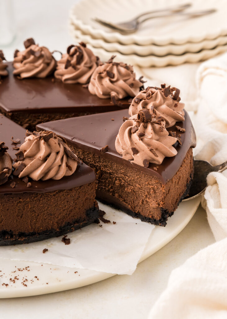 Triple chocolate cheesecake with a slice cut out of it.