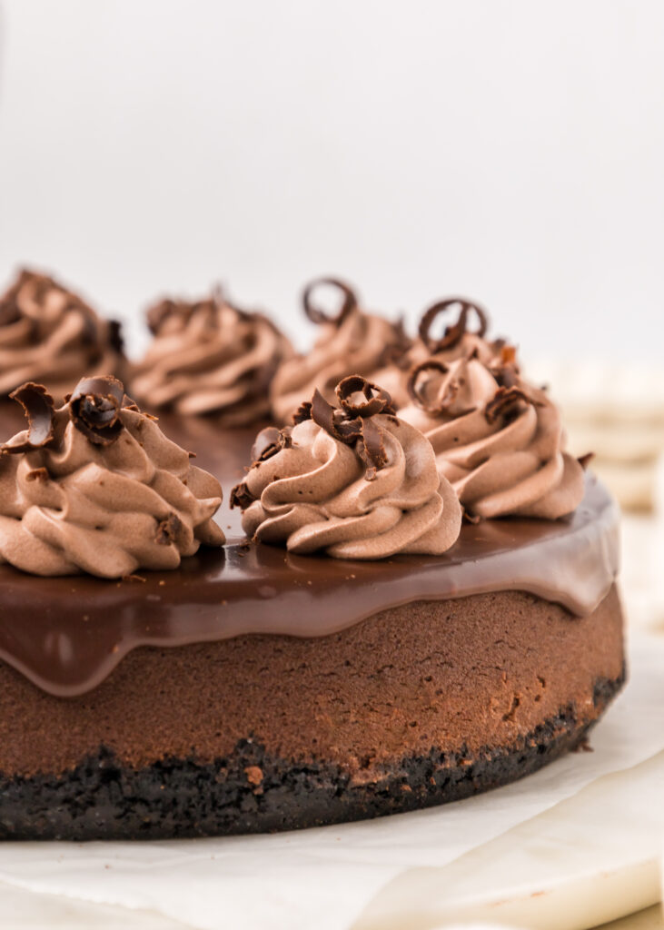 Chocolate whipped cream piped onto a chocolate cheesecake.