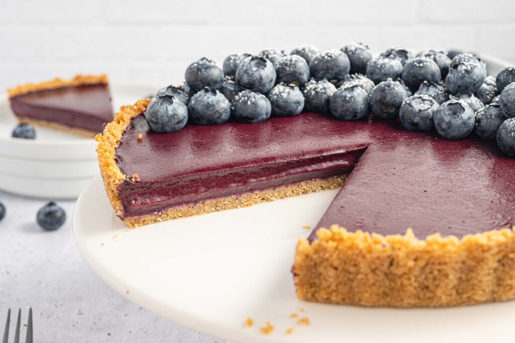 Blueberry Curd Tart with a slice missing.
