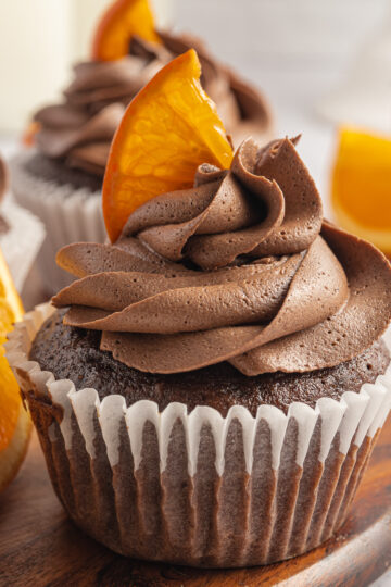 Chocolate Orange Cupcakes on wooden board with an orange slice on top