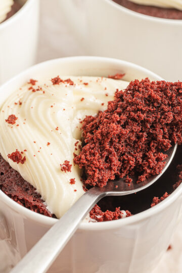 Red Velvet Mug Cake with a spoonful resting on top of the mug.