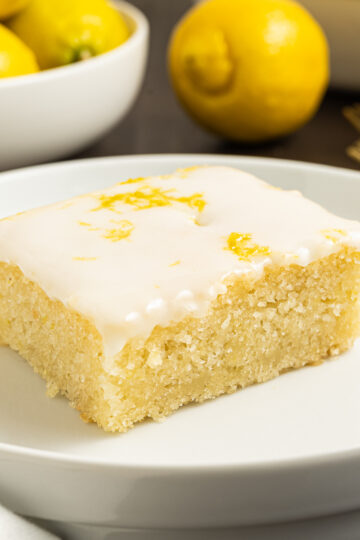 A slice of eggless lemon cake on a plate.