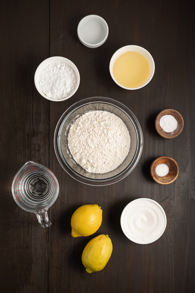Ingredients for an eggless lemon cake on a table.