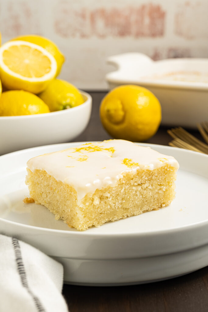 A slice of eggless lemon cake on a small plate.