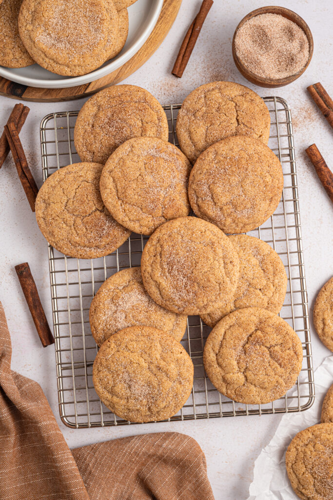 Maple snickerdoodles piled on a cooling rack.