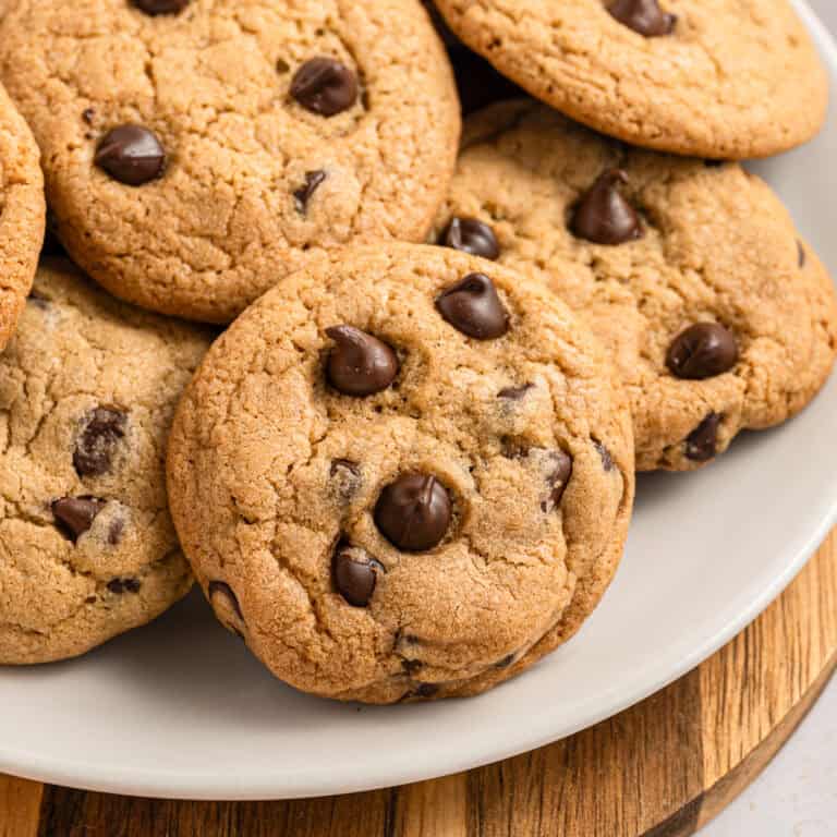 eggless chocolate chip cookies piled on a plate.