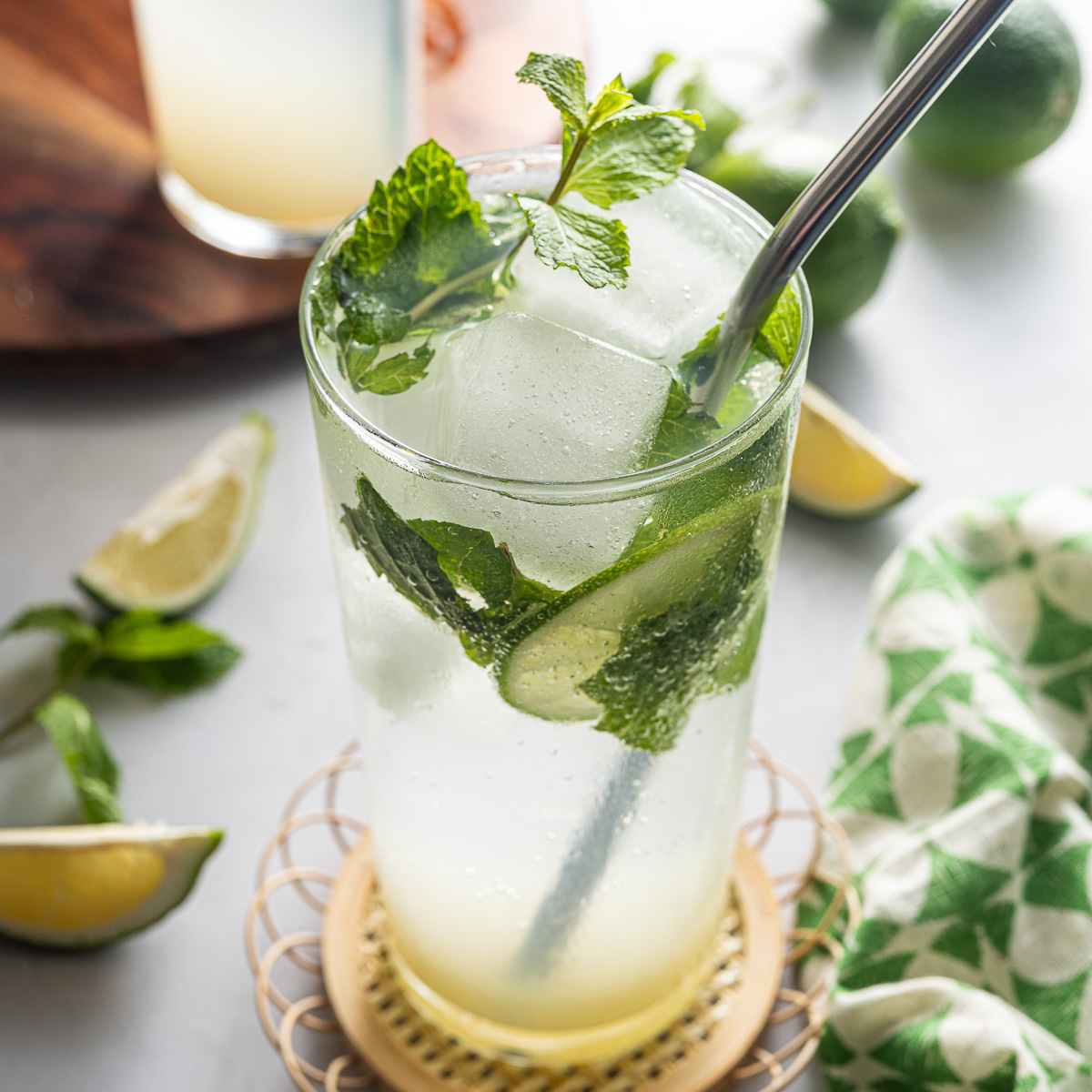 Nojito in a glass with a metal straw and mint sprig garnish.